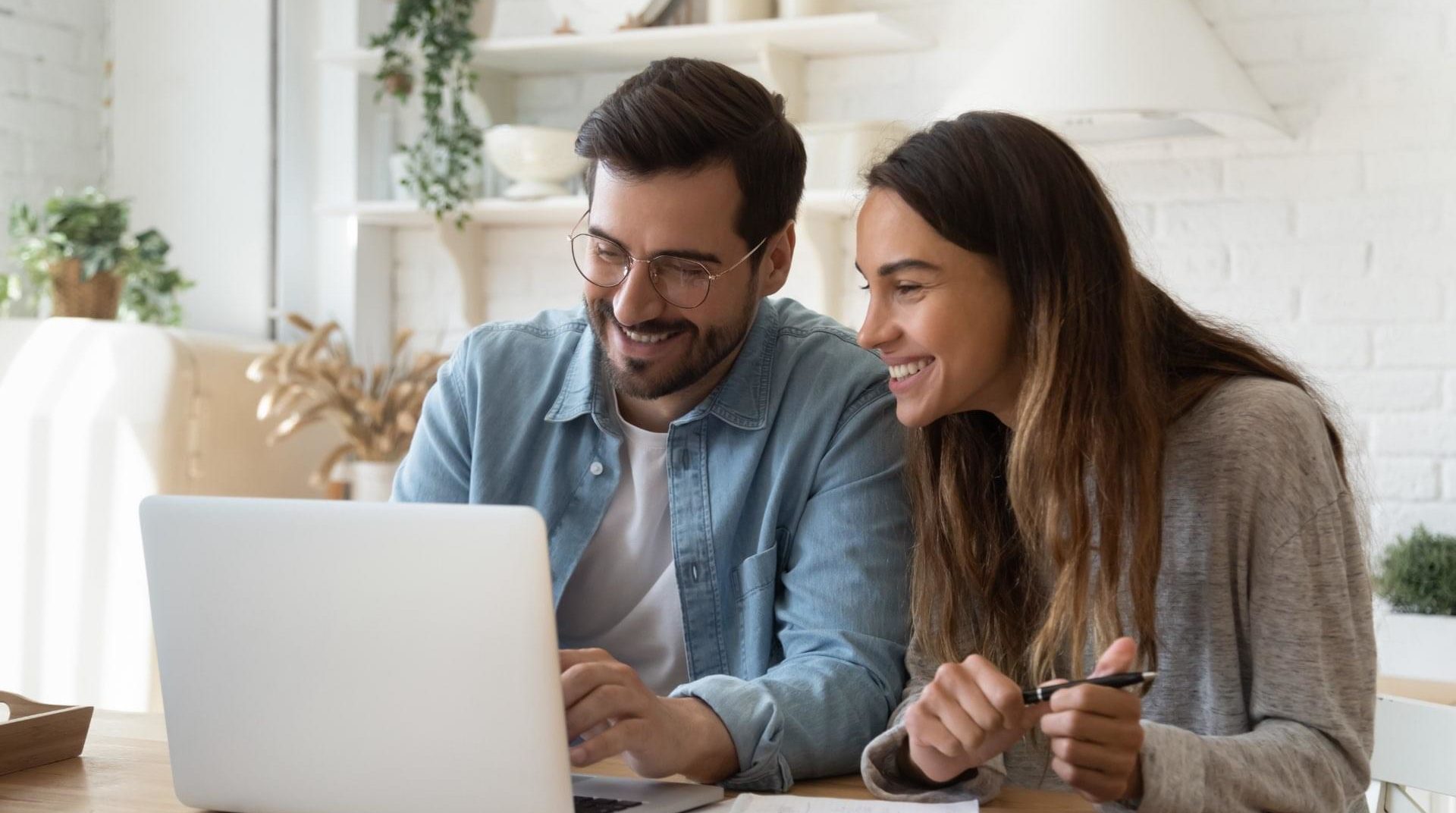 A man and woman enjoying internet through a laptop