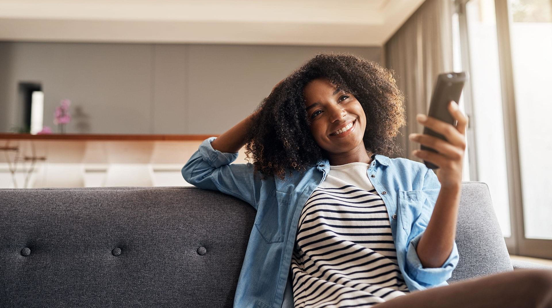 woman watching tv and holding remote