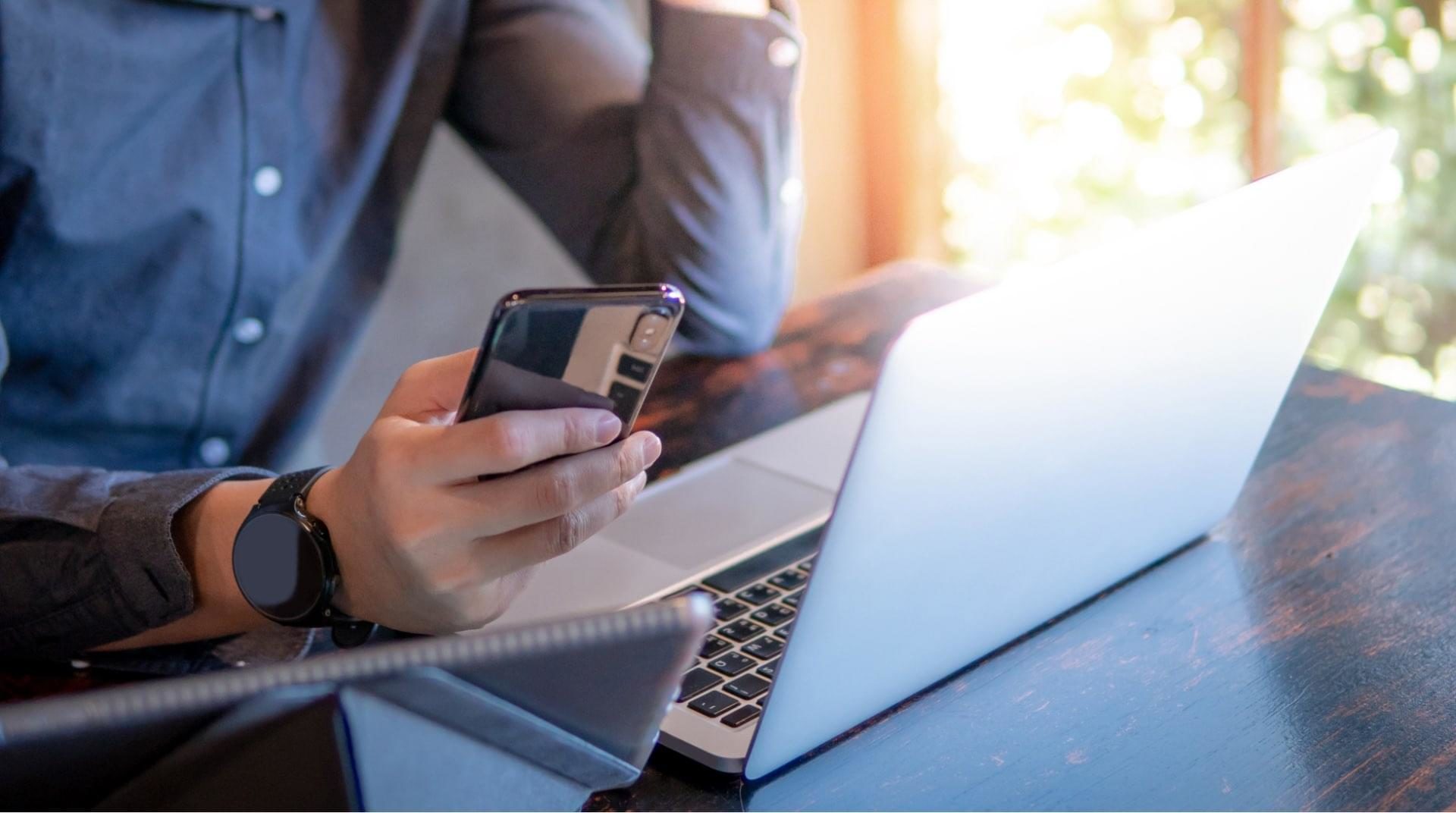 Man using phone and laptop